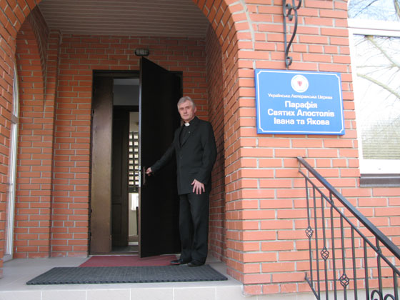 Пастор Тарас Коковський вітає в дверях храму
