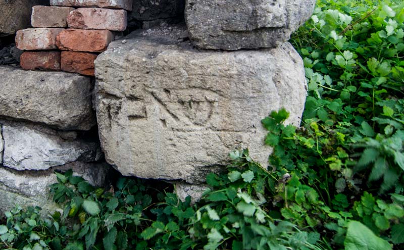 Одна з таємниць замку. Камінь з фрагментом єврейського напису. Літери, на жаль, хоч у хоч щось зрозуміле не складуються. Звідки взялася каменюка, та що це було від початку — незрозуміло. Достеменно можна сказати, що це не надгробок.