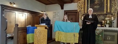 Пастор Майдану у Німеччині молиться з прапором, привезеним з передової російсько-української війни