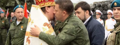 A UOC MP priest kisses the then leader of Russia's proxy "DNR" in eastern Ukraine, Aleksander Zakharchenko (center), with one of the leaders of the same group, Denis Pushilin, wanted in Ukraine and under international sanctions, behind him. Savur-Mohyla, Donetsk Oblast, 8 May 2015. 