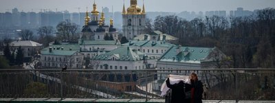 A woman puts on her headscarf in the courtyard of the Kyiv-Pechersk Lavra, also known as the Kyiv Monastery of the Caves, in Kyiv in April 2023.