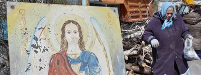 A woman walks next to a portrait of Christ as she collects what remains after a Russian rocket destroyed an Orthodox church on Easter night in Komyshuvakha in 2023.