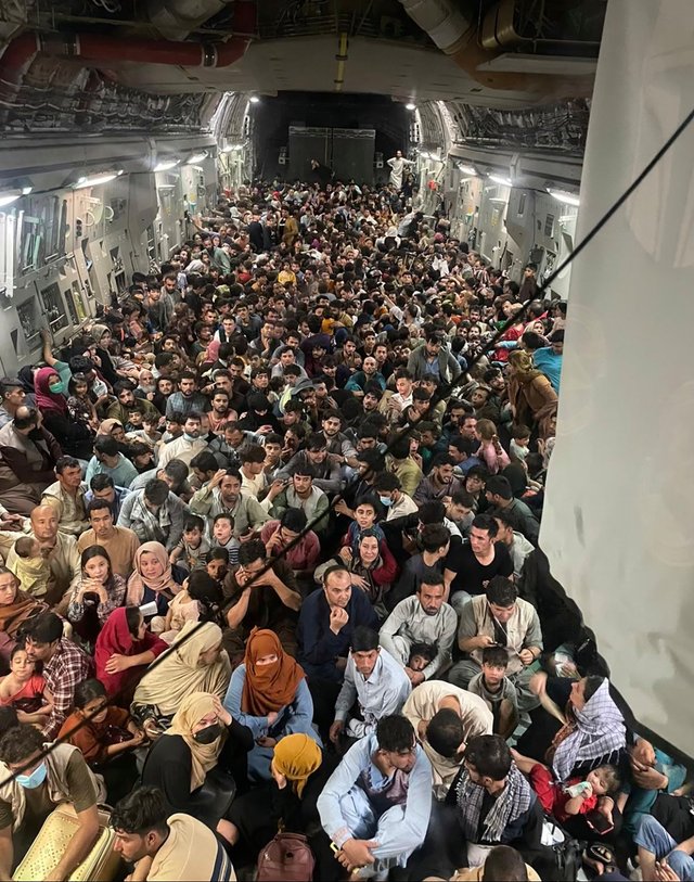 Американський лайнер C-17 не планував брати стільки людей, але афганці в паніці почали масово підійматися в літак через напіввідчинену рампу вантажного відділення, і екіпаж вирішив не висаджувати біженців силоміць. - фото 77584