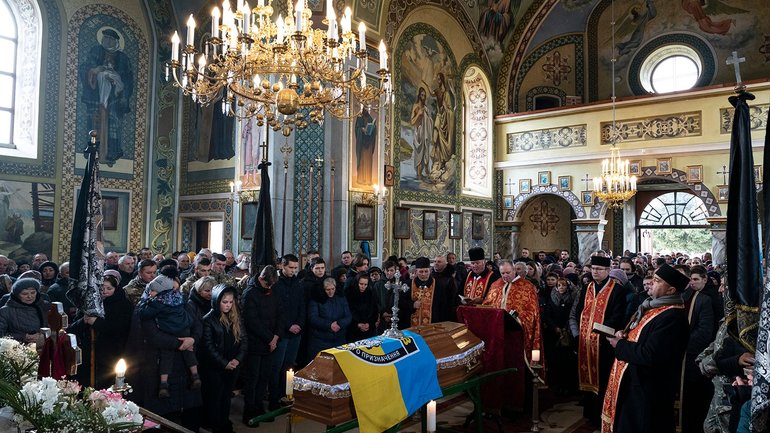 Relatives and friends attend the funeral of Roman Rushchyshyn, a senior police sergeant, near Lviv, western Ukraine, March 10, 2022. Rushchyshyn, a member of the Lviv Special Police Patrol Battalion, was killed in the Luhansk region - фото 1