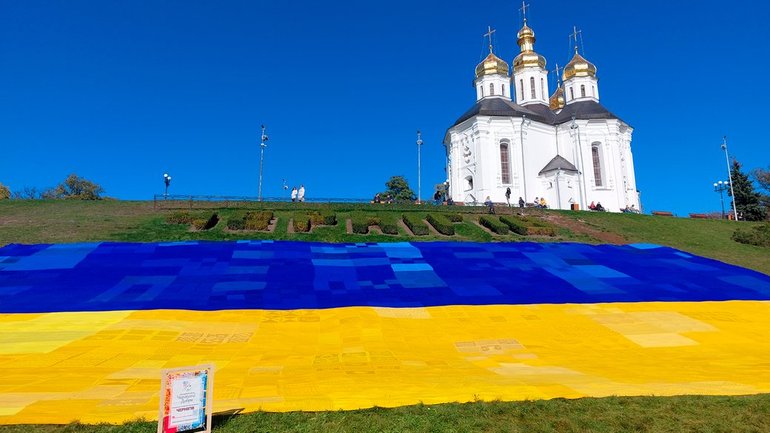Біля Катерининської церкви у Чернігові розгорнули найбільший в’язаний прапор України - фото 1
