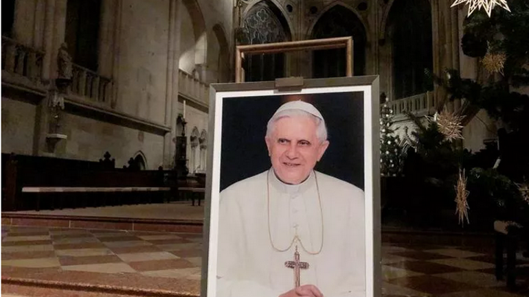 A portrait of Pope Emeritus Benedict XVI is seen near the altar at the Cathedral of Regensburg, southern Germany on December 29, 2022, during a church service. - фото 1