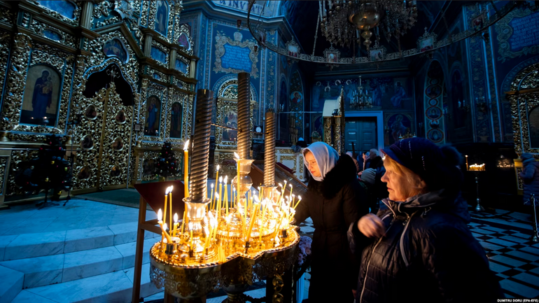 Believers light candles during the service for Orthodox Epiphany celebrations in the Nasterea Domnului Cathedral in Chisinau in January. - фото 1