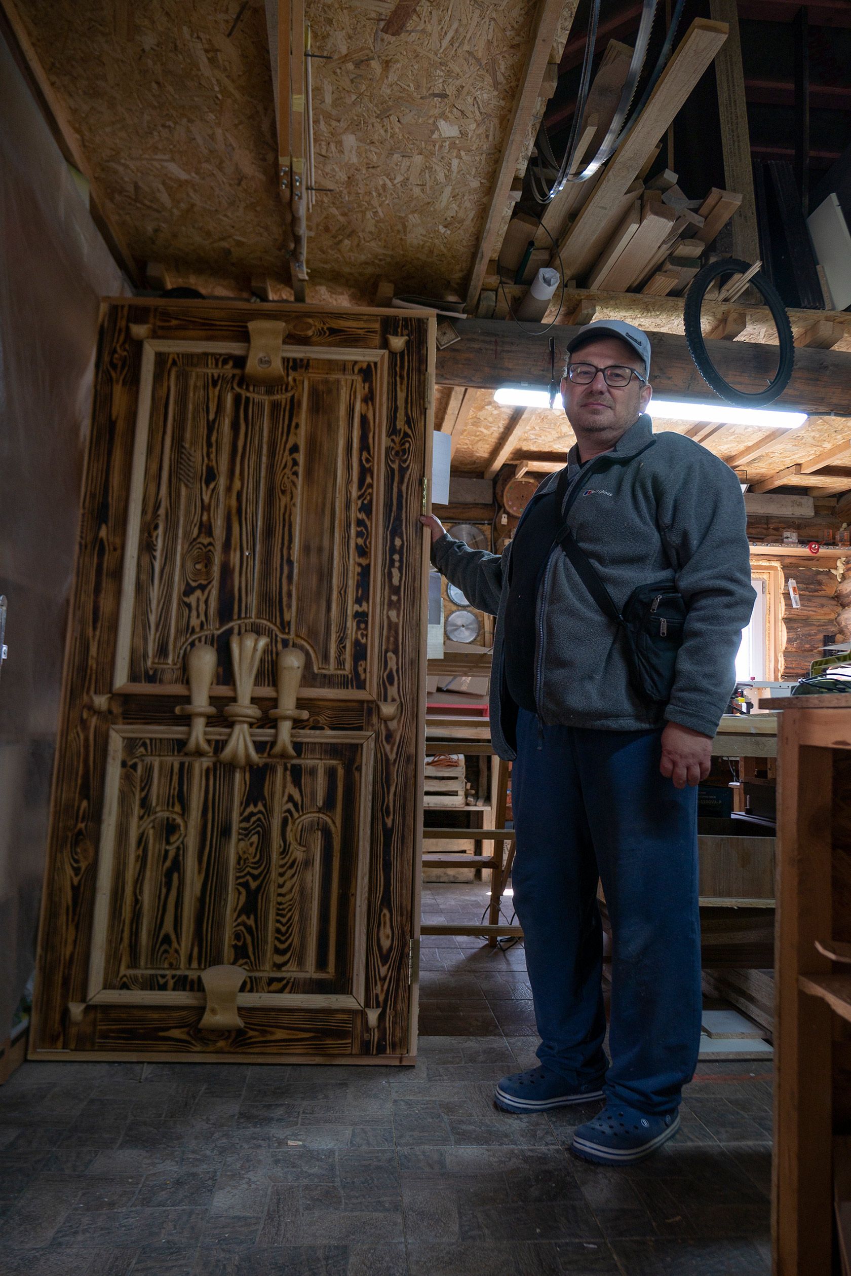 Працівник майстерні В’ячеслав показує дерев’яні двері, над якими працювали жителі Анатевки - фото 53730
