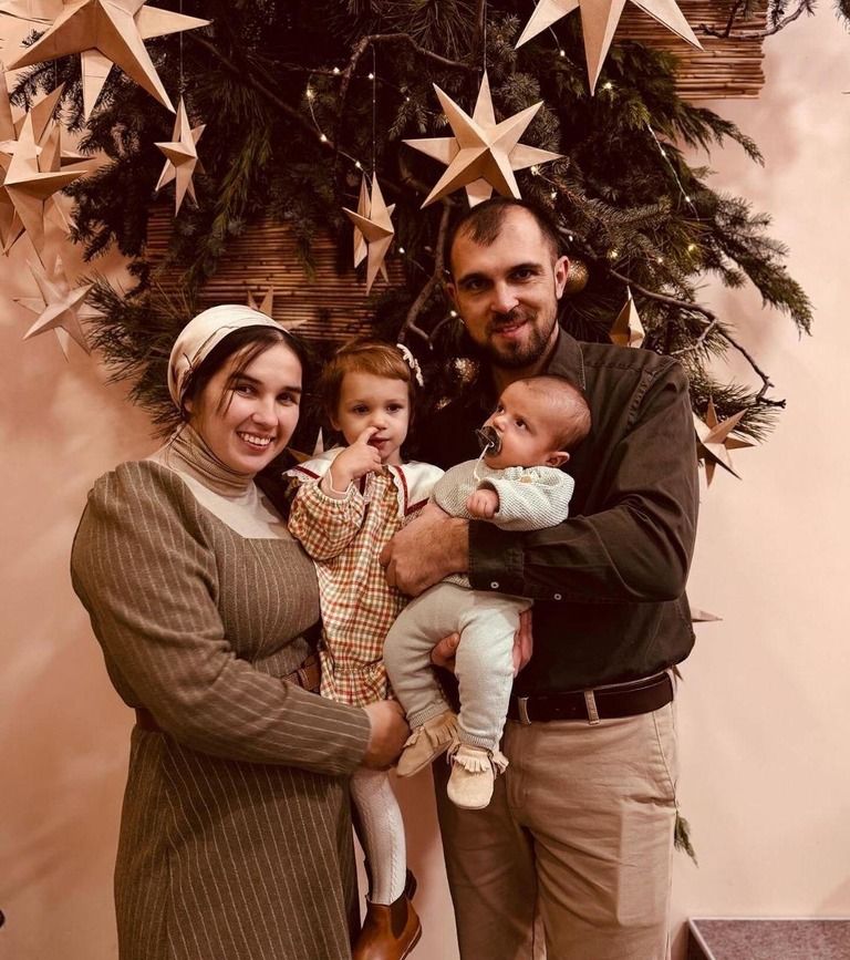 Подружжя Гайдаржи біля новорічної ялинки. Анна тримає на руках доньку Лізі, а Сергій – сина Тимофія - фото 134228