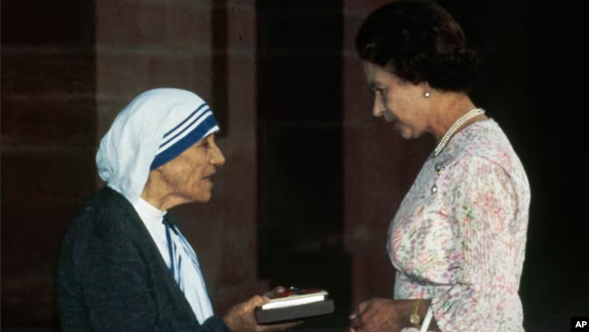 На цьому фото з архіву 24 листопада 1983 року Мати Тереза з Калькутти отримує відзнаку Почесного ордена 'За заслуги' від британської королеви Єлизавети II у Раштрапаті Шавар у Нью-Делі. - фото 134391