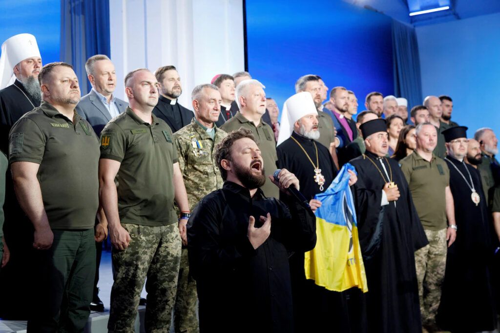 Singer Mykhailo Khoma, front, performs during the National Prayer Breakfast in Kyiv in June. - фото 140208