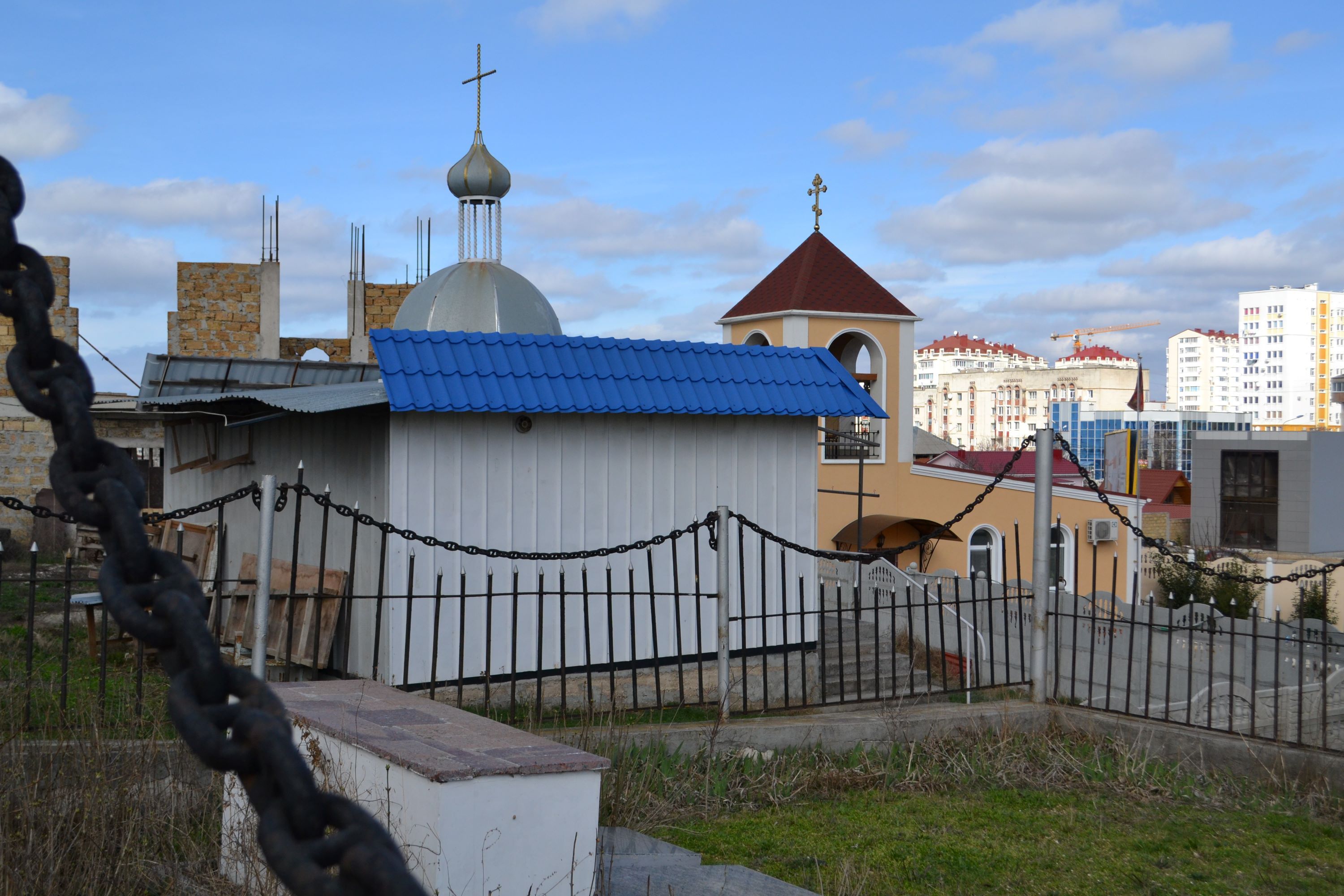 Підпис: Храм Успіння Пресвятої Богородиці (УГКЦ; перехрестя Фіолентівського шосе та вул. Хрустальова, м. Севастополь). На задньому фоні – процес зведення храму УПЦ МП   - фото 140270