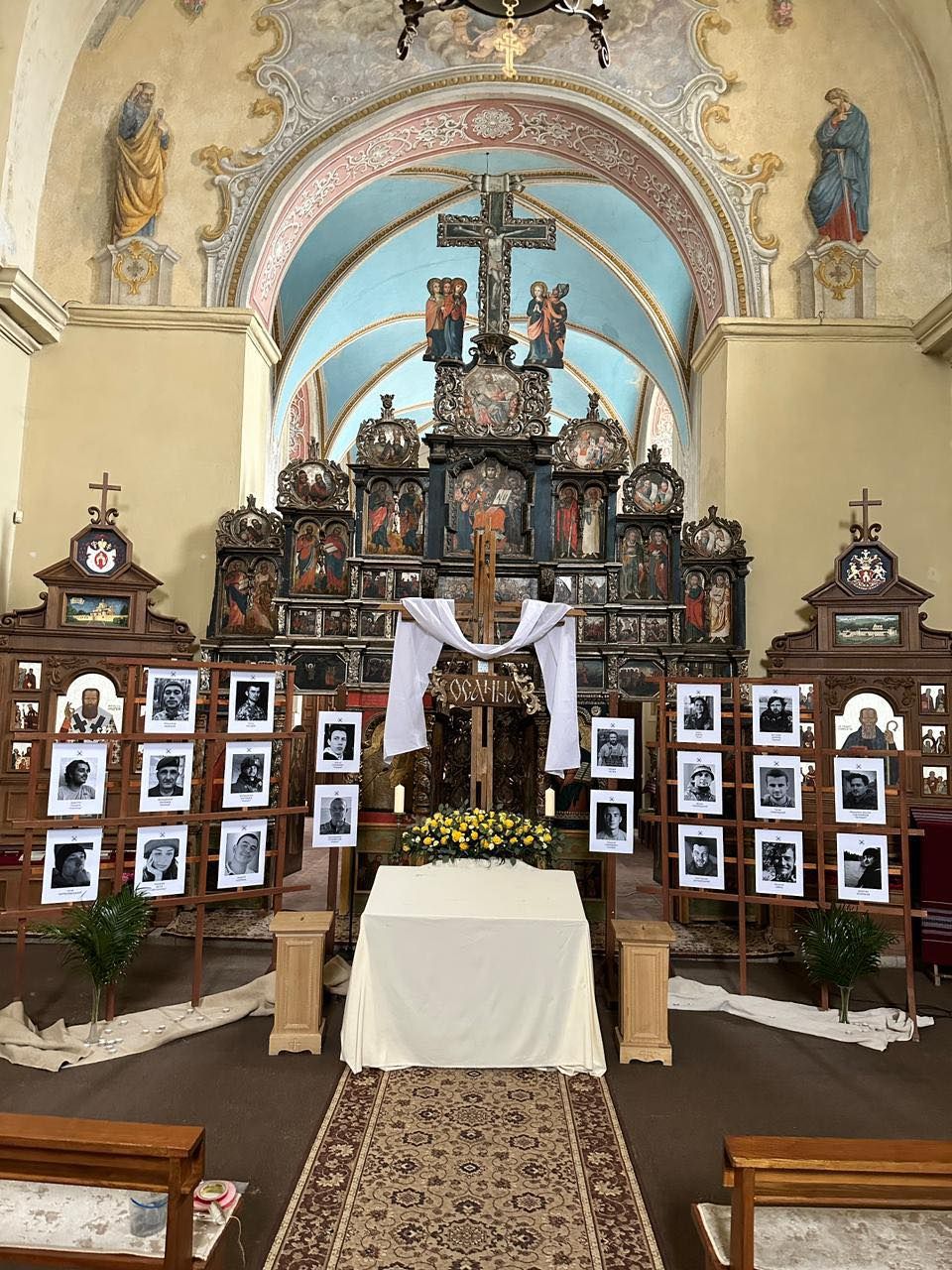 Це фото з храму Климентія Шептицького у Львові опублікувала вчора Іванка Димид. Інсталяція Андрія Винничка за ідеєю отця Севастьяна Дмитрух. Плащаниця тут цьогоріч лежатиме не серед квітів, а серед портретів загиблих захисників. Ті, хто віддали життя за нас — поруч розп’ятого Христа. - фото 168893