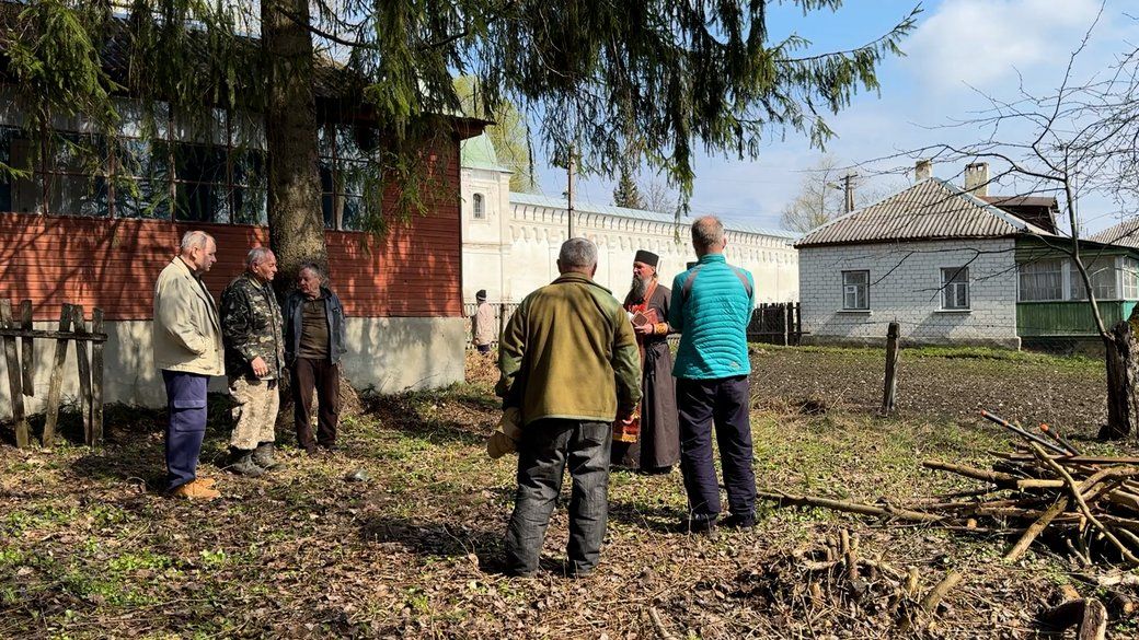 Люди зі священником ПЦУ поряд колишнього будинку УТОГ - фото 169348